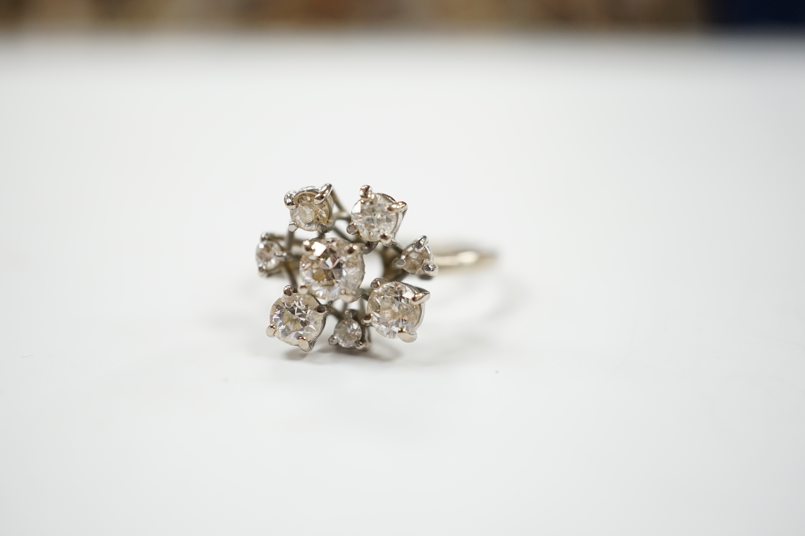 A modern 18ct white gold and graduated eight stone diamond cluster set dress ring, size S, gross weight 7 grams.